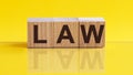 LAW Word On Wooden Blocks on yellow background. Law and Justice, Legality concep Royalty Free Stock Photo