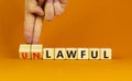 Lawful or unlawful symbol. Businessman turns wooden cubes and changes the word unlawful to lawful. Beautiful orange table, orange Royalty Free Stock Photo