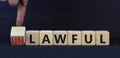 Lawful or unlawful symbol. Turned wooden cubes and changed the concept word Unlawful to Lawful. Beautiful grey table grey