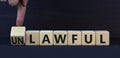 Lawful or unlawful symbol. Turned wooden cubes and changed the concept word Unlawful to Lawful. Beautiful grey table grey