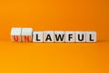 Lawful or unlawful symbol. Turned wooden cubes and changed the word unlawful to lawful. Beautiful orange table, orange background Royalty Free Stock Photo