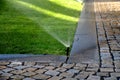 Watering lawn automatic irrigation with pull-out sprinklers fresh green color black plastic nozzles extend and rotate in a circle Royalty Free Stock Photo