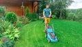 Lawn care. Mowing grass with an electric lawn mower. A young man mows the grass with a lawn mower with a grass collector on a Royalty Free Stock Photo