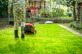 Lawn care - teenager cutting lawn in small garden with electric lawn mower