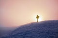 On the lawn covered by snow there is someone standing. Fantastic sunrise. Landscape with the mountains. Morning fog in pink colors Royalty Free Stock Photo