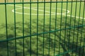 Lawn field for playing minifootball behind the green fence mesh