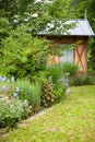 Lawn with flower bed and a beautiful garden hut in the background Royalty Free Stock Photo