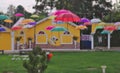 Lawn garden decorated with colorful umbrellas, rainy season, old bike decorated European model house wall background Painted Royalty Free Stock Photo