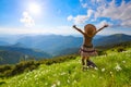 On the lawn in mountains landscapes the hipster girl in dress, stockings and straw hat stays watching the sky with clouds. Royalty Free Stock Photo