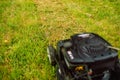 Lawn mover on green grass in modern garden. Machine for cutting lawns. Royalty Free Stock Photo