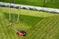 Lawn mower cutting grass on green field in yard. Mowing gardener care work tool Royalty Free Stock Photo