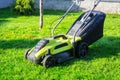 Lawn mower cutting green grass in backyard Royalty Free Stock Photo