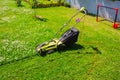 Lawn mower cutting green grass in backyard Royalty Free Stock Photo