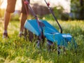 A man mows green grass in his backyard with an electric lawn mower Royalty Free Stock Photo