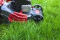 Lawn mower cutting green grass in backyard Royalty Free Stock Photo
