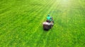 Lawn mower with gardener. Grass cutting. Aerial from drone.