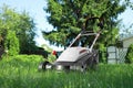 Lawn mower on green grass in garden, low angle view Royalty Free Stock Photo