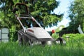 Lawn mower on green grass in garden, low angle view Royalty Free Stock Photo