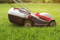 Lawn mower on a green meadow. Lawn Mower In Garden. Details of landscaping and gardening