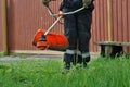 Lawn mower with a hand trimmer mows the local area Royalty Free Stock Photo