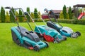 . Lawn mowers are standing on the lawn in the garden backyard. A close-up of an electric lawn mower