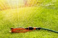 Lawn sprinkler spaying water over green grass Royalty Free Stock Photo