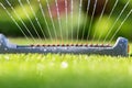 Lawn sprinkler spaying water over green grass.