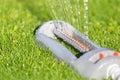 Lawn sprinkler spaying water over green grass. Royalty Free Stock Photo