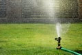 Lawn sprinkler watering green grass Royalty Free Stock Photo