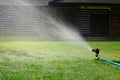 Lawn sprinkler watering green grass