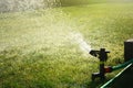 Lawn sprinkler watering green grass Royalty Free Stock Photo