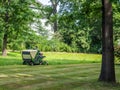 Lawn tractor mows lawn in the park Royalty Free Stock Photo