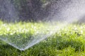 Lawn Water Sprinkler Spraying Water Over Grass In Garden On A Hot Summer Day. Automatic Watering Lawns. Gardening And Environment