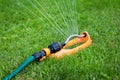 Lawn watering - water sprinkler working in green grass