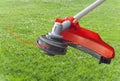 Lawnmower big head trimmer red machine on green grass in the garden