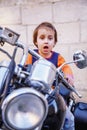 Laws for child drivers under 18 concept. Portrait of cute little biker child girl sitting on a motorcycle Royalty Free Stock Photo