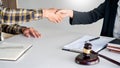 Lawyer or attorneys shaking hand with client after consultation discussing a contract agreement customer at courtroom, judge