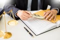 Lawyer being offered receiving money as bribe from client at desk in courtroom Royalty Free Stock Photo