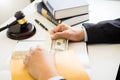 Lawyer being offered receiving money as bribe from client at desk in courtroom Royalty Free Stock Photo