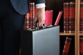 Lawyer Carrying Briefcase Against Bookshelf