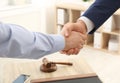 Lawyer handshaking with client over table in office Royalty Free Stock Photo