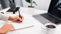 Lawyer of handwriting civil and criminal indictment on the desk with laptop and coffee, house plant working at the home office Royalty Free Stock Photo