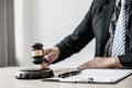 A lawyer or legal advisor holding a small hammer for a judge`s table in court is about to pound on the podium to deliver a fair Royalty Free Stock Photo