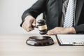 A lawyer or legal advisor holding a small hammer for a judge`s table in court is about to pound on the podium to deliver a fair Royalty Free Stock Photo