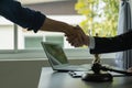 A lawyer shakes hands with a businessman to close a deal with a lawyer to discuss the contractual terms