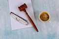 Lawyers Judge desk with wooden judges gavel a cup of coffee, notebook of reading glasses Royalty Free Stock Photo