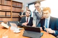 Lawyers in their law firm working on computer with books in background Royalty Free Stock Photo