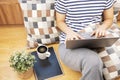 Lay flat view of asian woman working at home with laptop and black coffee on wooden floor shows concept of working from anyway by Royalty Free Stock Photo