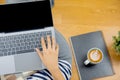 Lay flat view of asian woman working at home with laptop, pillow and latte coffee on wooden floor shows concept of working from Royalty Free Stock Photo