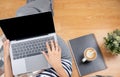Lay flat view of asian woman working at home with laptop, pillow and latte coffee on wooden floor shows concept of working from Royalty Free Stock Photo